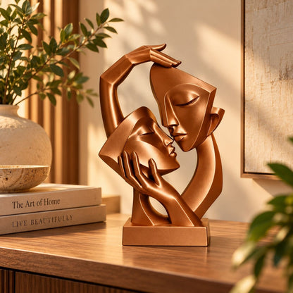 Copper abstract couple sculpture on a wooden console with books and plant